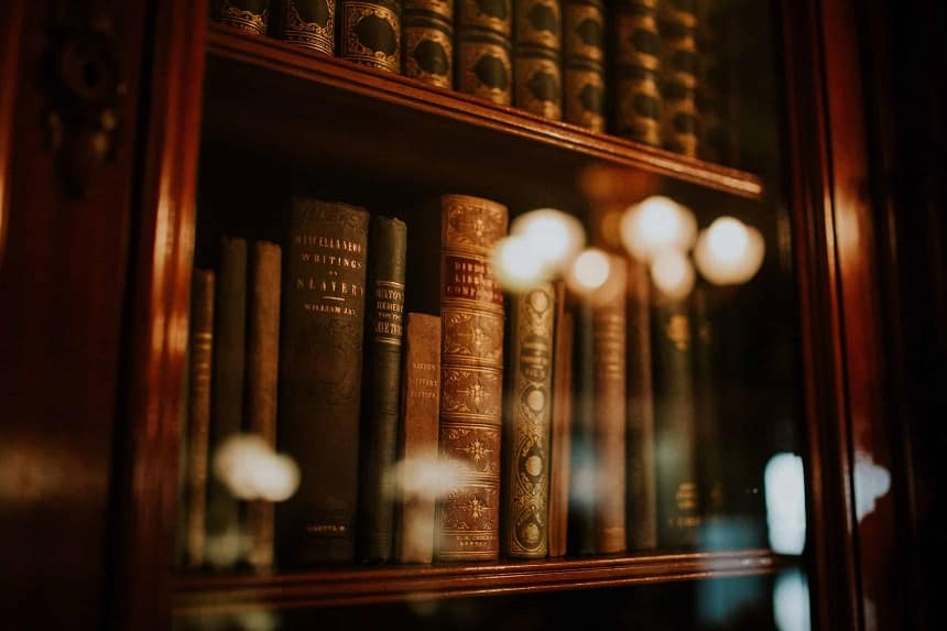 Kuvassa antiikkinen kirjahylly, joka on lukuisia kirjoja.