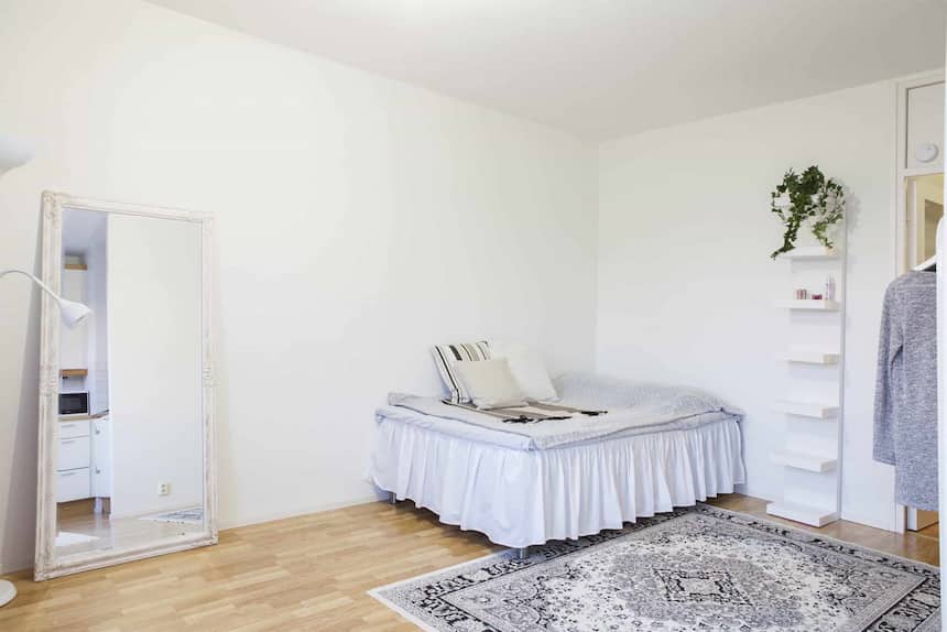 Kuvassa esittelykuva Seinäjokilaisen asunnon olohuoneesta, jossa sohva, sänky ja matto.
